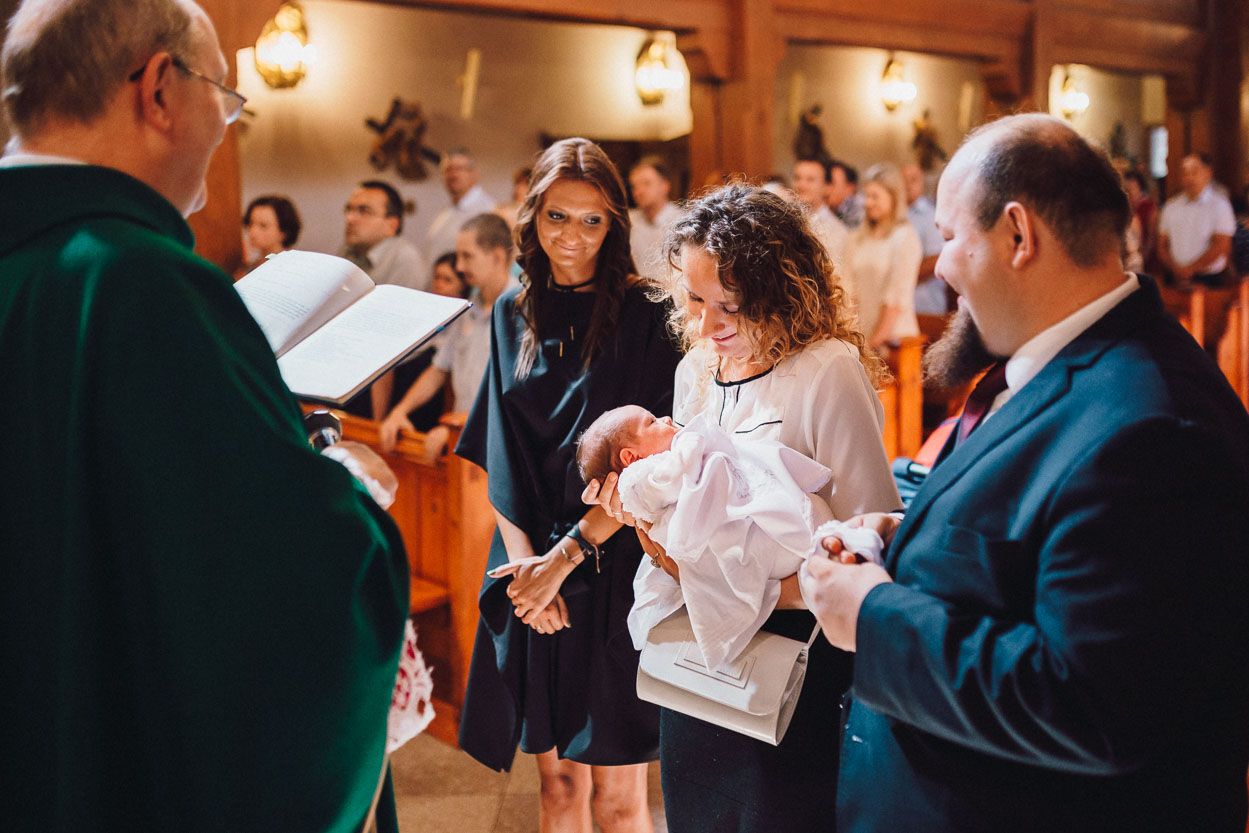Moment chrztu świętego - rodzice trzymają dziecko