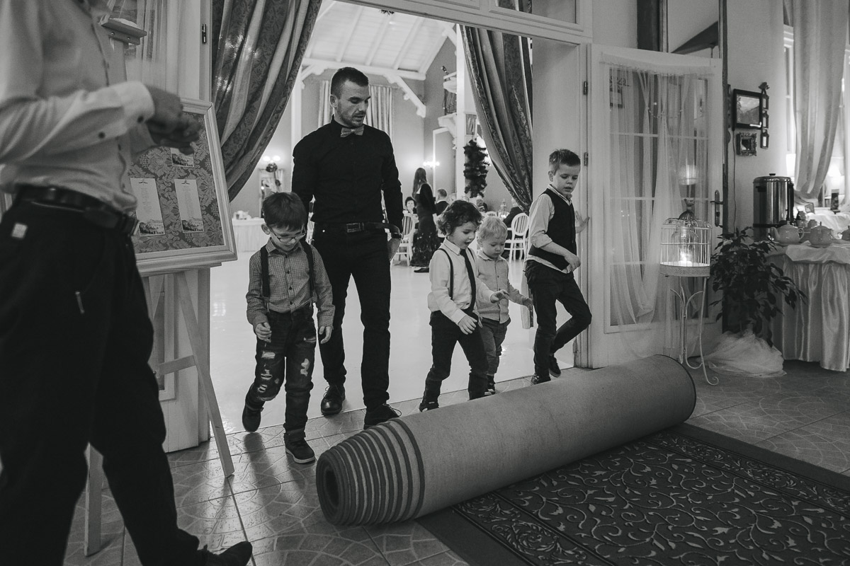 Mali chłopcy i menadżer sali hotelu Dwór Korona Karkonoszy zwijają dywan w hotelu Dwór Korona Karkonoszy.