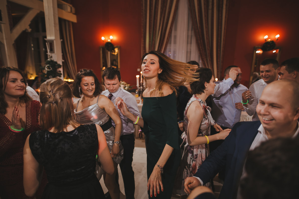 Kobieta tańczy pośród gości weselnych podczas przyjęcia w hotelu Dwór Korona Karkonoszy.