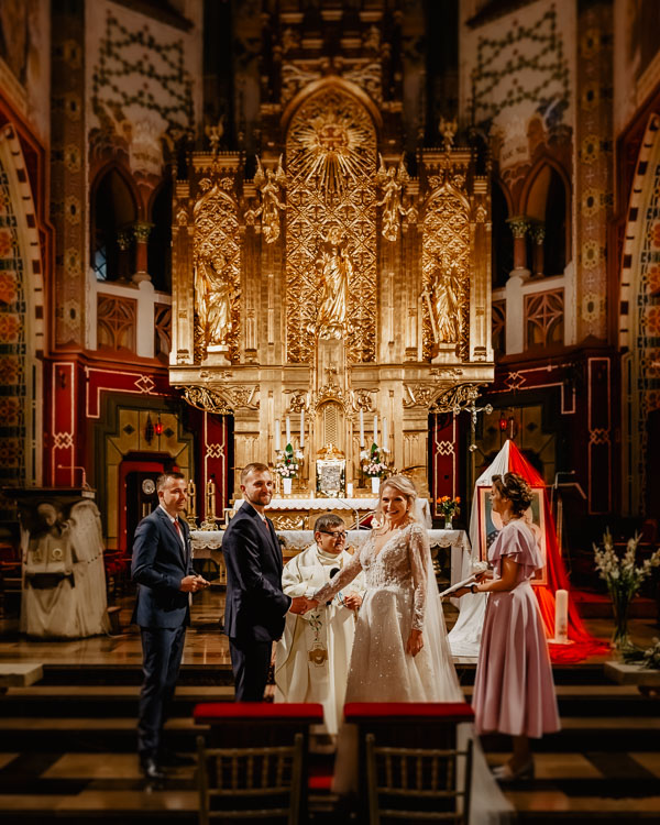 Para Młoda na tle ołtarza w trakcie ślubu kościelnego