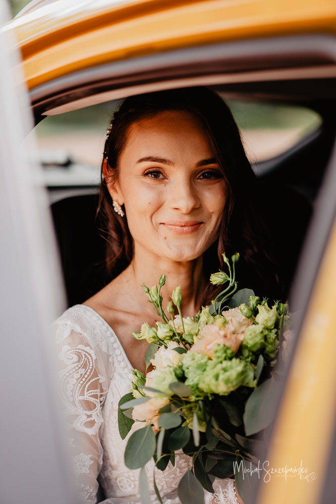 Portret Panny Młodej w samochodzie do ślubu.